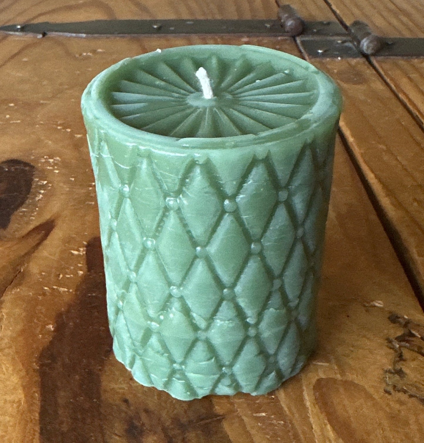 Green tufted diamond patterned pillar candle with sunburst top. Made from pure beeswax in California.
