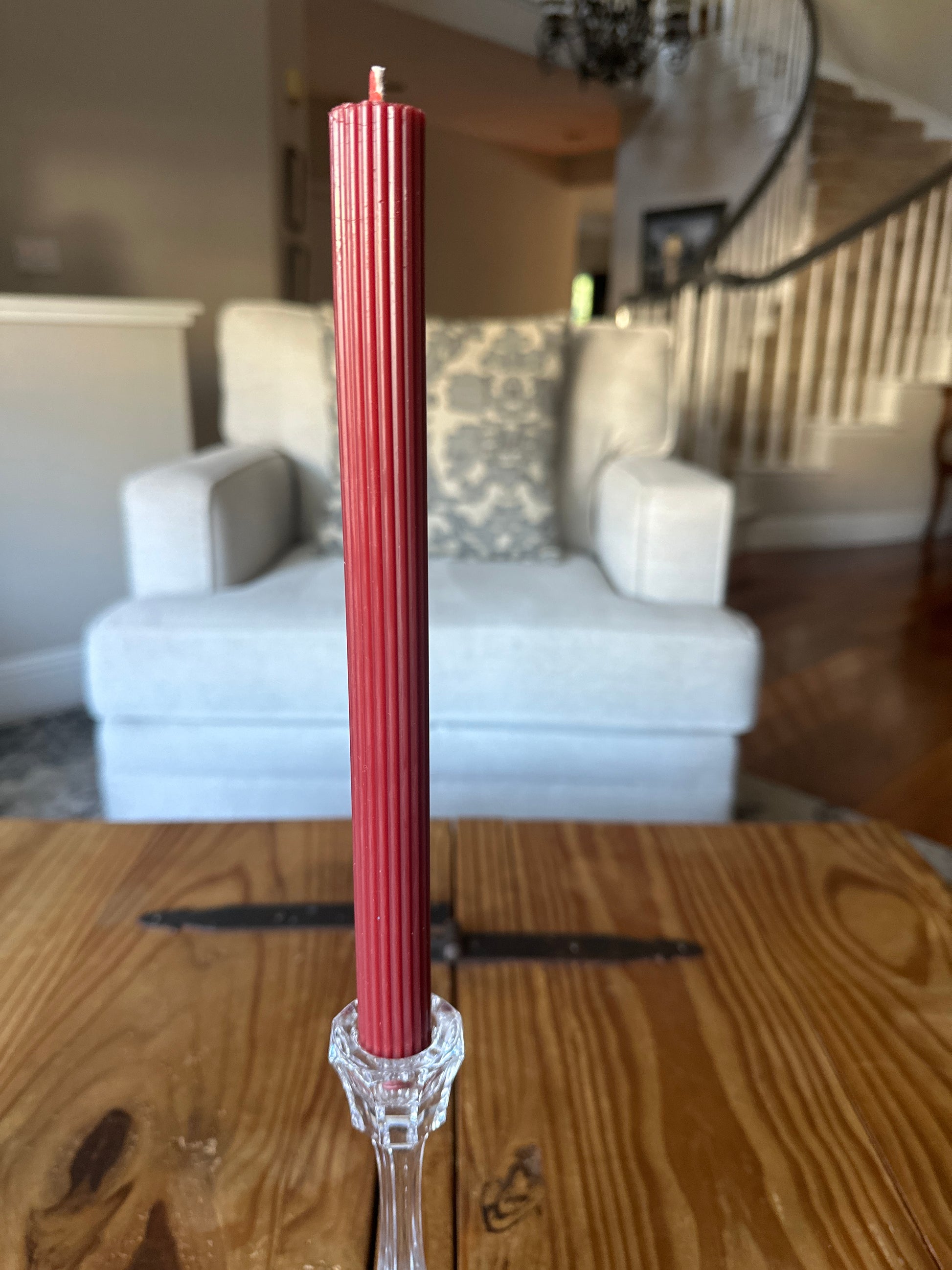 Red Ribbed Taper dinner candle on rustic table in home