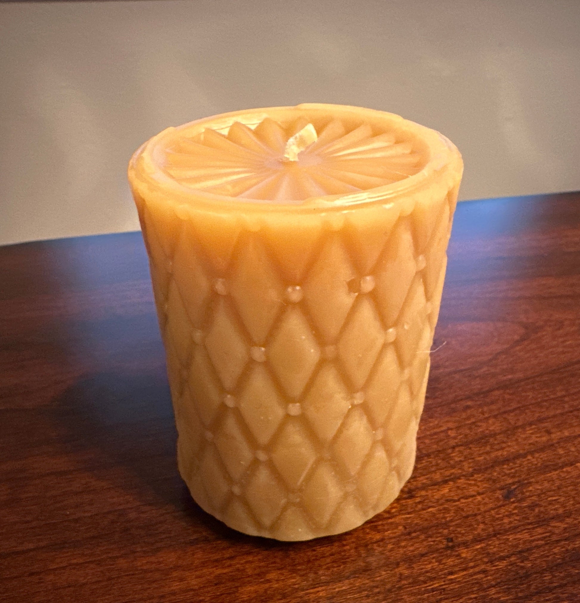 Pure Beeswax pillar candle with tucked diamond pattern and sunburst top made in california.  Natural beeswax gold color.