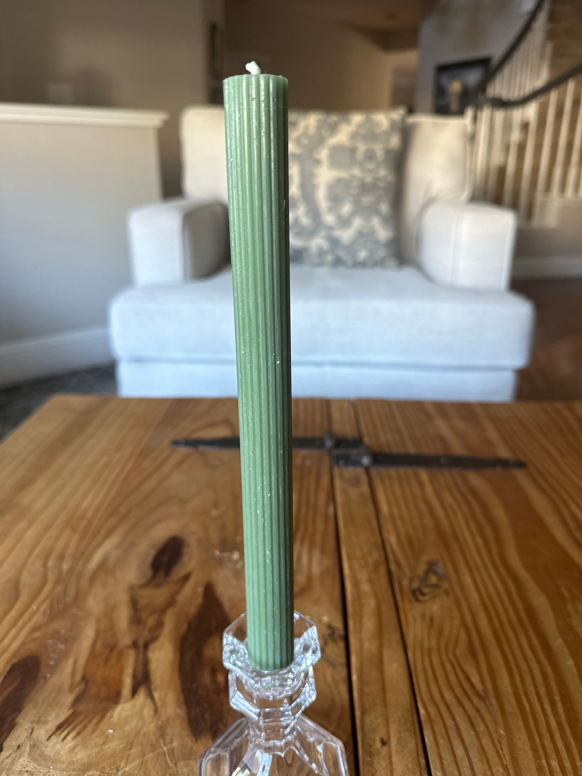 Light Green Ribbed Dinner Candle on rustic wooden table in home