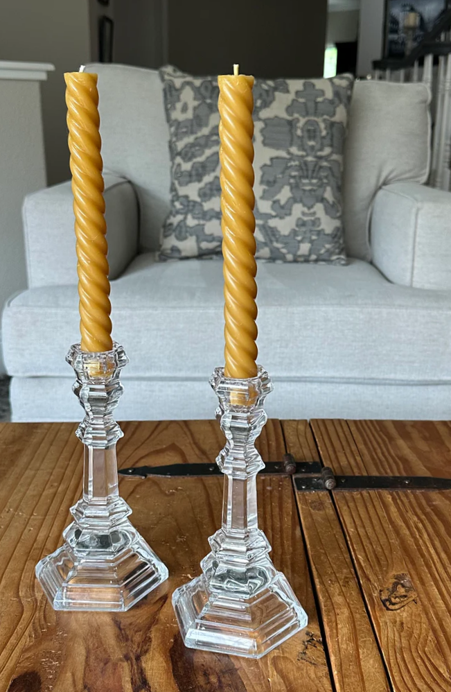 Spiral twisted natural beeswax candles made in California on a rustic wooden table.