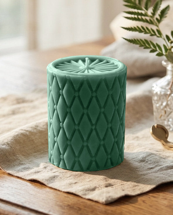 Green Beeswax pillar candle with tucked diamond pattern and sunburst top made in california.   