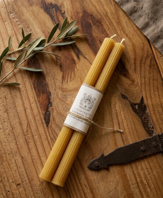 Ribbed taper candles on a rustic wooden table.